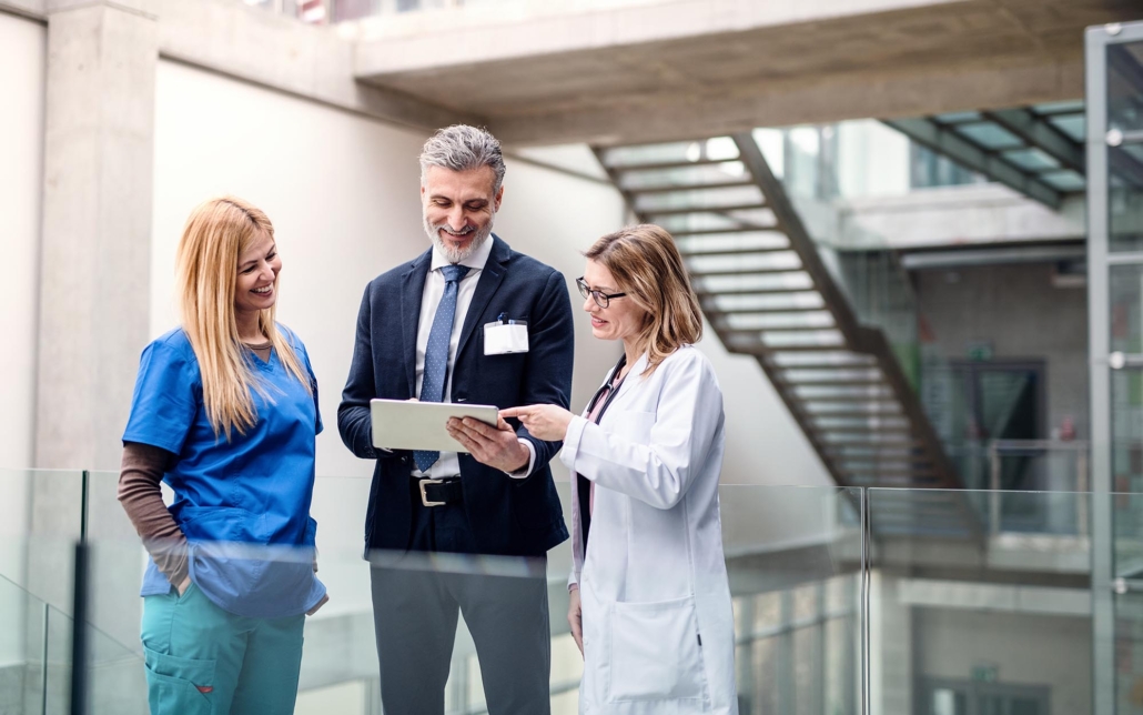 coworkers looking over tablet in hospital stairs