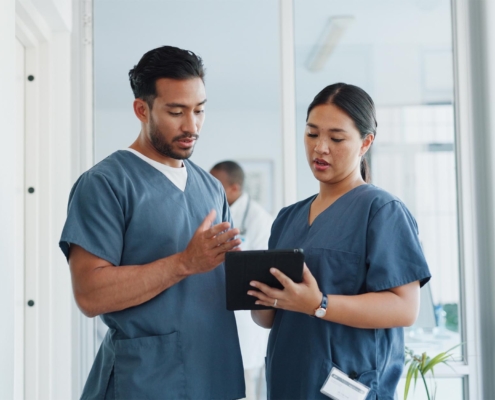 Two healthcare workers looking at tablet