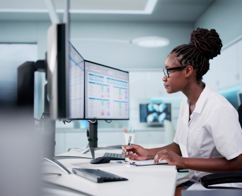 Hospital Doctor Using Spreadsheet For Billing Codes On Desktop